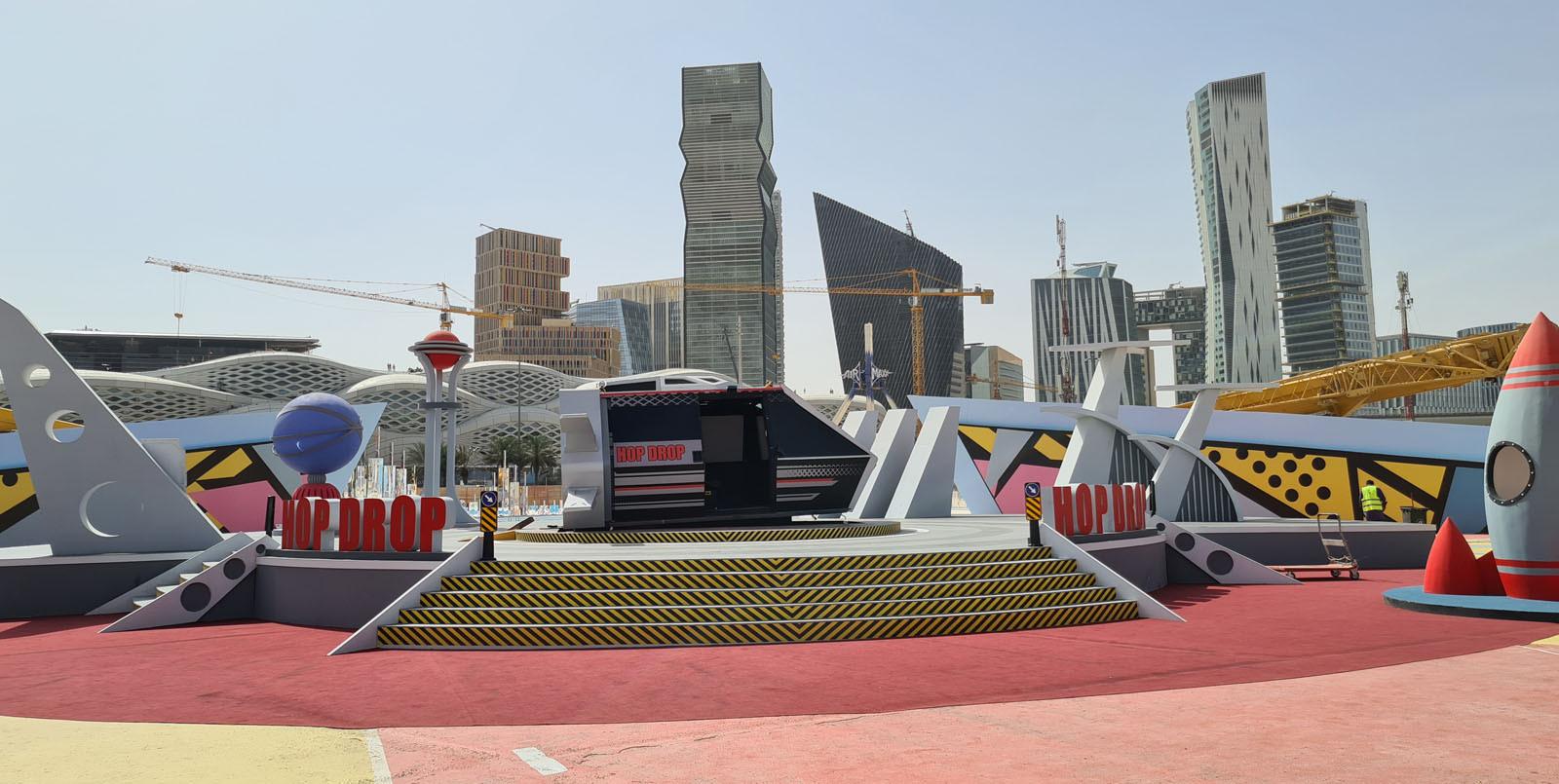 on set of Ramez, a rocket shaped capsule placed amongst a pop art futuristic set